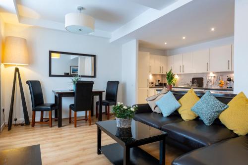 uma sala de estar com um sofá e uma sala de jantar em Inverness City Suites em Inverness