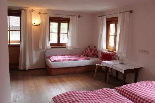 a room with a bed and a couch and windows at Uhlerhof in Stumm
