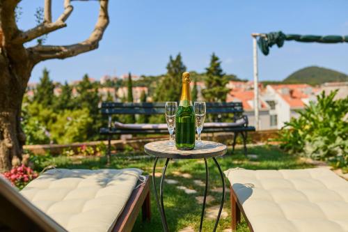 a bottle of champagne sitting on a table with two glasses at Guest House Anica in Dubrovnik