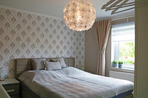 - une chambre avec un lit et un lustre dans l'établissement Dein Ferienhaus in Wernigerode, à Wernigerode