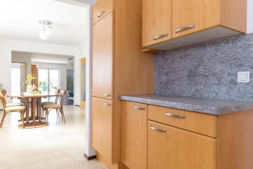 a kitchen with wooden cabinets and a table with chairs at Domizil Illmitz in Illmitz