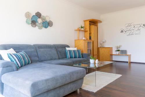 a living room with a blue couch and a table at Domizil Illmitz in Illmitz
