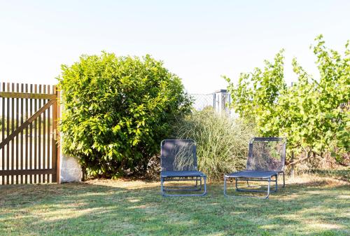 two chairs sitting in the grass next to a fence at Domizil Illmitz in Illmitz