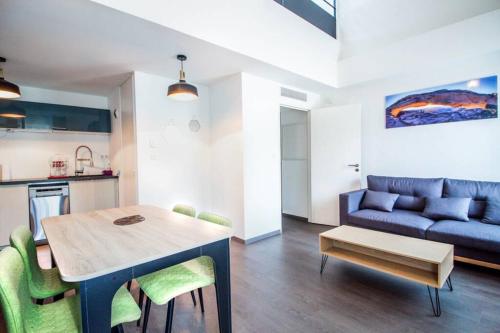 un salon avec une table et un canapé bleu dans l'établissement APPARTEMENT HAUSSMANNIEN TYPE LOFT, CLIMATISE - VIEUX-PORT-LE PANIER,, à Marseille