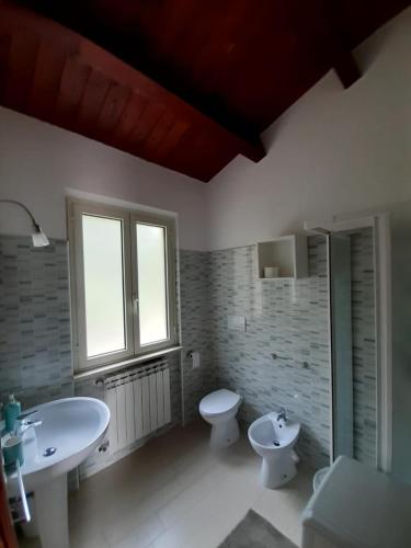 a bathroom with two sinks and a toilet and a window at Casale Angela in Torrevecchia Teatina