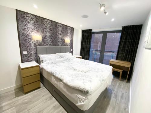 una camera da letto con un grande letto bianco e una finestra di Cosy City Centre Location, Hydro Massage Showe a Manchester