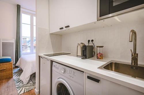une cuisine avec une machine à laver et un évier dans l'établissement Hyper-Centre - Cathédrale - Mairie, à Reims
