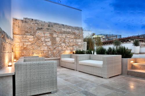 a patio with wicker chairs and a stone wall at Palazzo Calò in Bari