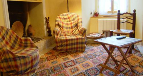 ein Wohnzimmer mit 2 Stühlen und einem Tisch in der Unterkunft Les volets bleus in Gresse-en-Vercors