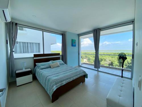 - une chambre avec un lit et une grande fenêtre dans l'établissement Magico Apartamento Frente al Mar 3 Habitaciones FB73, à Coveñas