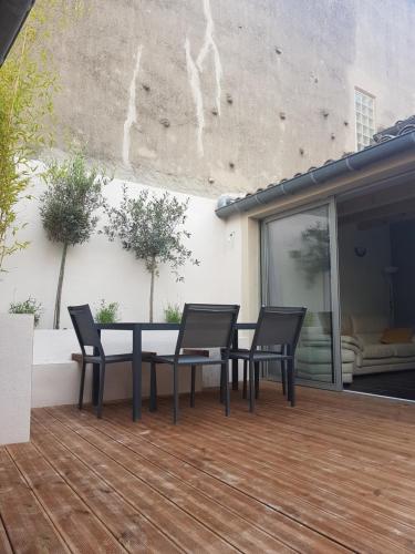 un patio avec une table et des chaises sur une terrasse dans l'établissement Maison vue Cité 2, à Carcassonne
