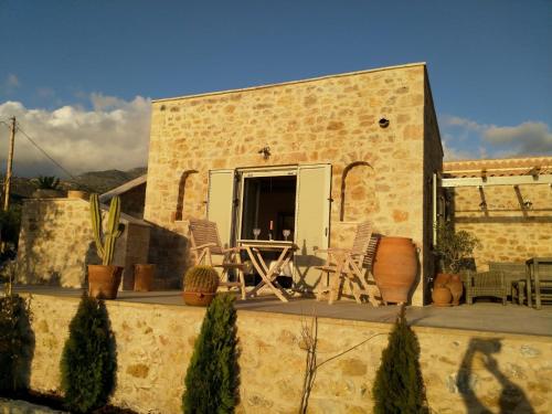 a building with a patio with chairs and a table at The Mousehouse in Áno Rínglia