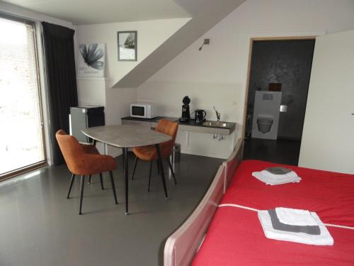 a room with a table and chairs and a bed at B&B Altijd Genieten in Damme