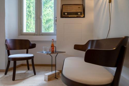 a room with a chair a table and a television at Villa Pineta in Fusio