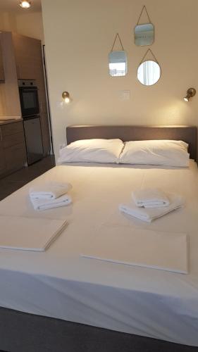 a large white bed with two towels on it at Athina View Studio in Nea Peramos