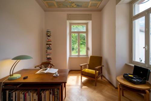 a room with a desk and a chair and windows at Villa Pineta in Fusio
