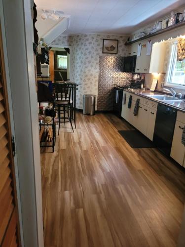 a kitchen and living room with a wooden floor at Kountry Living Bed and Breakfast in Oneonta