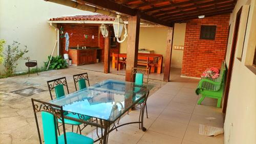 Varandas do Arraial- Hostel في أرايال دو كابو: طاولة زجاجية وكراسي على الفناء