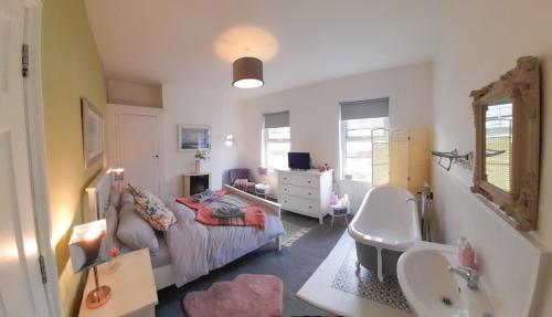 a bathroom with a bed and a sink in a room at Beautiful Victorian Terraced House in Eastbourne