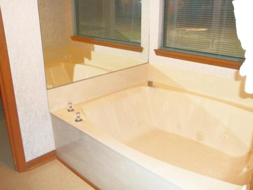 a white bath tub in a bathroom with a window at Fairways of the Mountain, a VRI resort in Lake Lure
