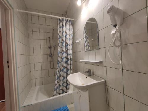 a bathroom with a sink and a shower and a tub at Domus in Ustka