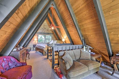 a attic room with a bed and a couch at Irwin A-Frame Cabin with Deck and Mountain Views! in Irwin