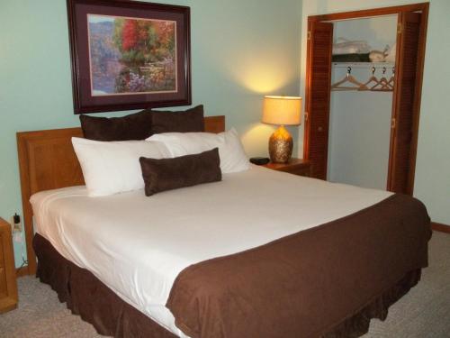 a large white bed in a room with a lamp at Fairways of the Mountain in Lake Lure