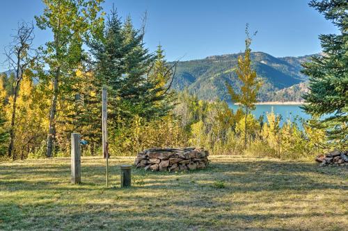 a pile of logs in a field next to a lake at Irwin A-Frame Cabin with Deck and Mountain Views! in Irwin