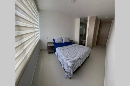 a bedroom with a bed in a white room at Estrene apto VIP en el mejor condominio campestre 753 in Girardot