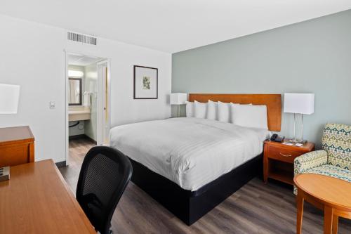 a hotel room with a bed and a table and a chair at Vagabond Inn Glendale in Glendale