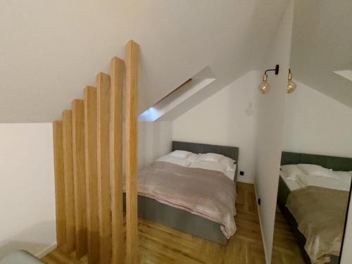 a small bedroom with a bed and a stair case at Cicha 3 in Sztutowo