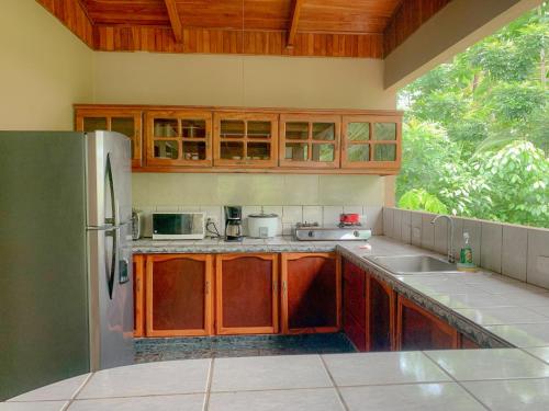 a kitchen with wooden cabinets and a stainless steel refrigerator at Tranquilidad Resort in Parrita