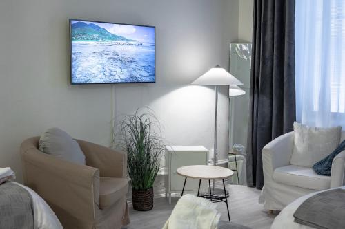 uma sala de estar com uma televisão pendurada na parede em Hotel Lemonade em Gotemburgo