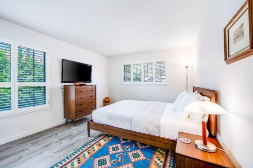 a bedroom with a bed and a flat screen tv at Mountain View Modern Condo Permit# 4340 in Palm Springs