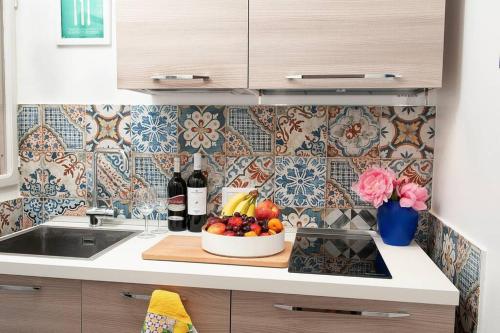a kitchen with a bowl of fruit on a cutting board at Blue Sea House in Cefalù