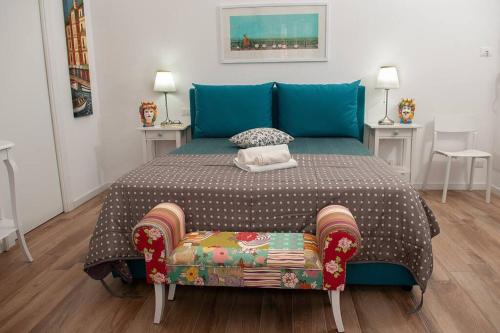 een slaapkamer met een bed met een blauw hoofdeinde bij Blue Sea House in Cefalù
