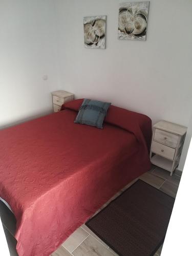 1 dormitorio con 1 cama roja y 2 mesitas de noche en Piso Mesa del Mar, en Tacoronte