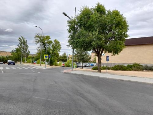 an empty street with a tree and a building at TOLETUM low cost LOFTS diáfanos o 2dormitorios PARKING Municipal Gratis al aire libre a 100m in Toledo