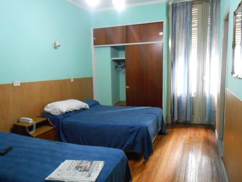 Habitación de hotel con 2 camas y ventana en Hotel San Martin en Buenos Aires