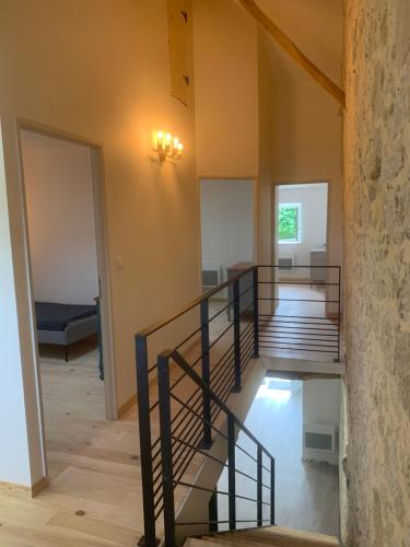 - un escalier dans une chambre dotée d'un mur en pierre dans l'établissement L’Estable du Pin, à Le Pin