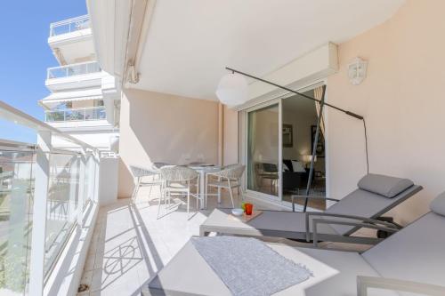 une chambre avec un balcon avec une table et des chaises dans l'établissement 3-Room Apartment in Prestigious Residence, à Cannes