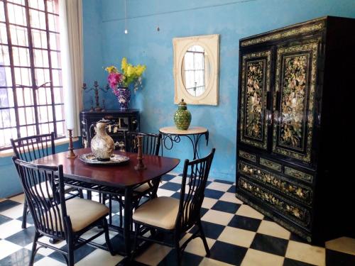 a dining room with a table and chairs and a mirror at Catrina & Diego in Mérida