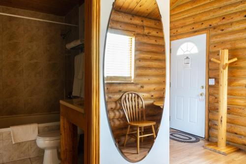 dos fotos de un baño con una tabla de surf en la pared en Country Cabins Inn, en Lyman