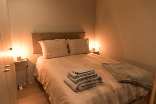 1 dormitorio con 1 cama con toallas en Sal, Terra e Mar, en Aveiro