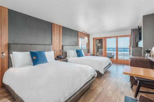 a hotel room with two beds and a desk at Headlands Coastal Lodge & Spa in Pacific City