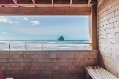 a window with a view of the ocean with a bench at Headlands Coastal Lodge & Spa in Pacific City