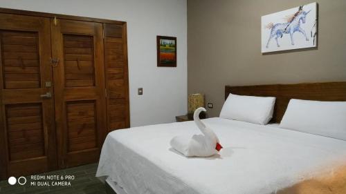 a swan sitting on a bed in a bedroom at Hotel Maria Maria in Bacalar