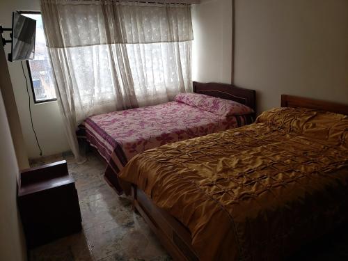 een slaapkamer met 2 bedden en een raam bij Apto Duplex Familias Numerosas Centro Pasto in Pasto