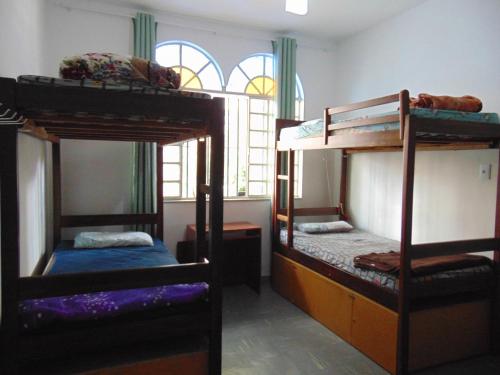 a room with three bunk beds and a window at Wally's House Hostel in Belo Horizonte