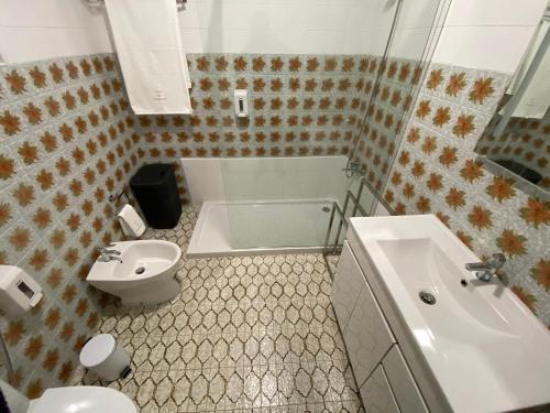 a bathroom with a tub and a toilet and a sink at CASA do CAMINHO in Praia da Vitória